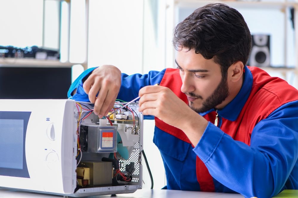 A man working diligently on a computer in an office, specializing in kitchen appliance repair services in Everett, WA.